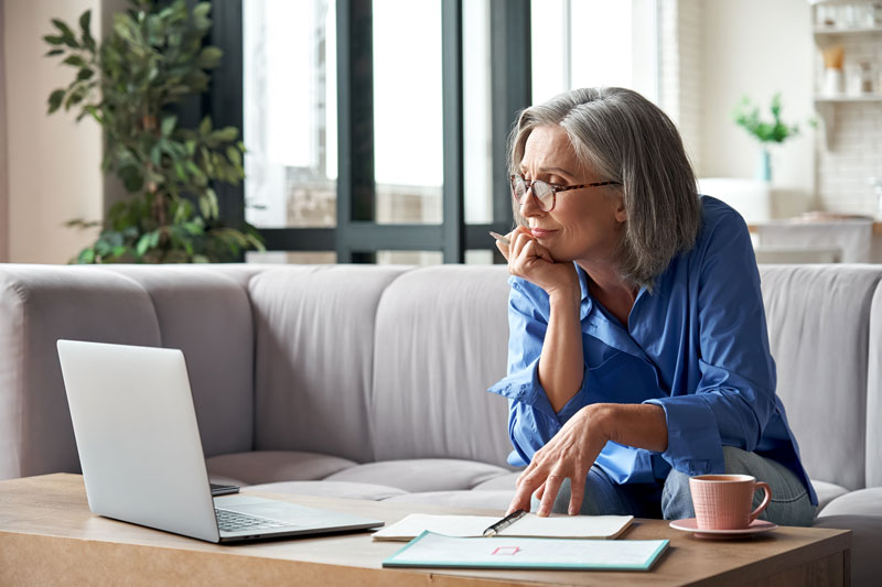 woman wearing glasses looking at laptop