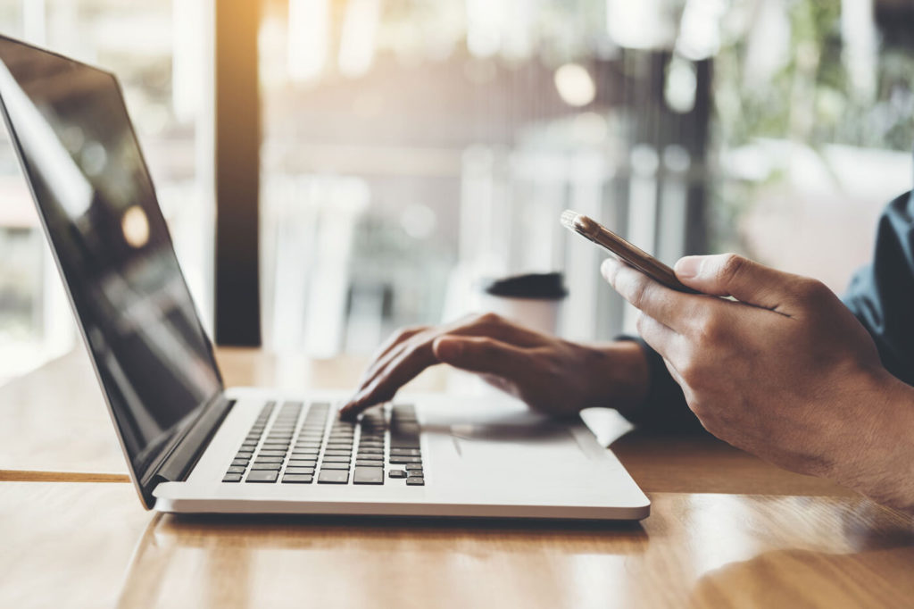 side view of person using phone and laptop