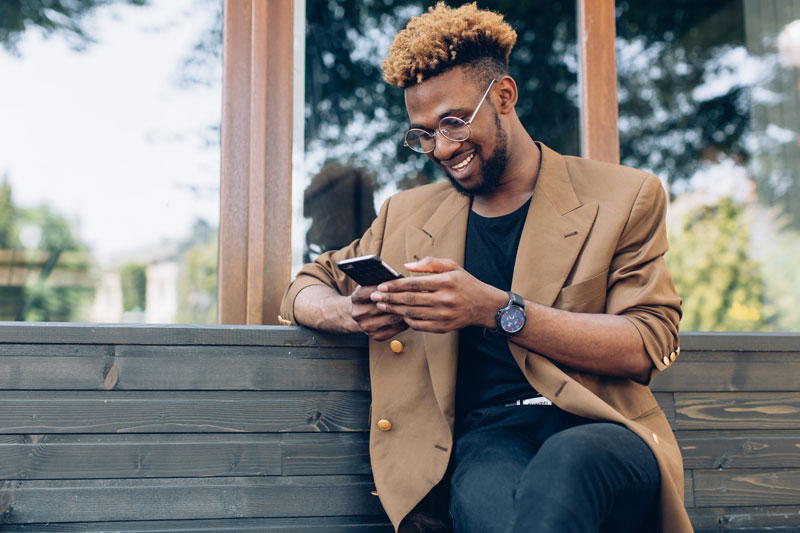 man sitting on a bench on his phone
