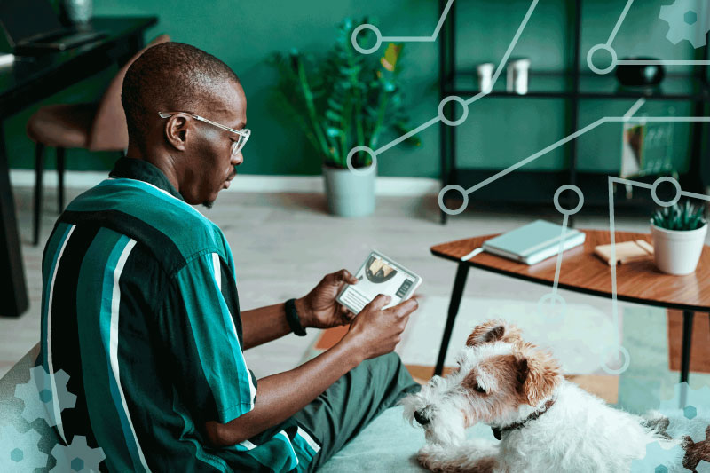 person using an ipad sitting on the couch next to their dog